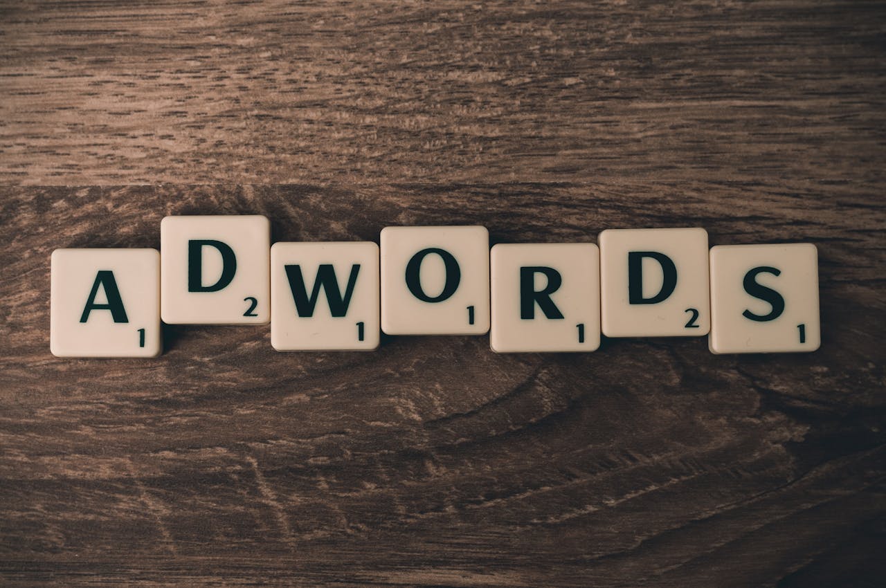 services-02 Scrabble tiles spelling 'AdWords' on a wooden surface, symbolizing digital marketing concepts.